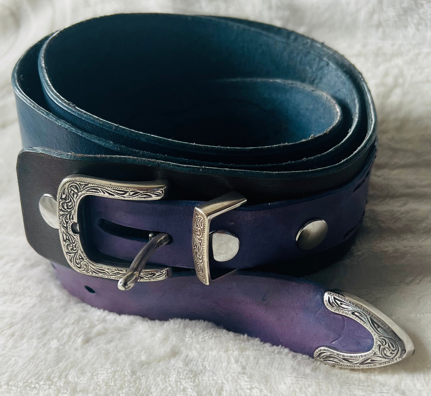 Teal belt with purple design at the ends. Stylish Silver buckle and tip.